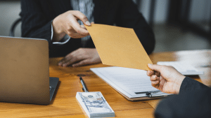 person handing someone an envelope